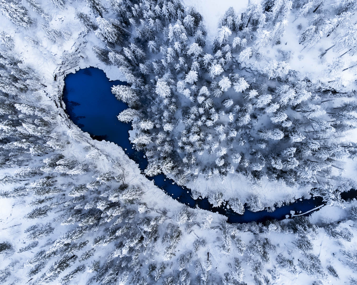 A photo of a cold blue stream covered in snow